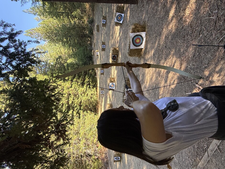 Attendee drawing a longbow on the Camp Navarro archery range